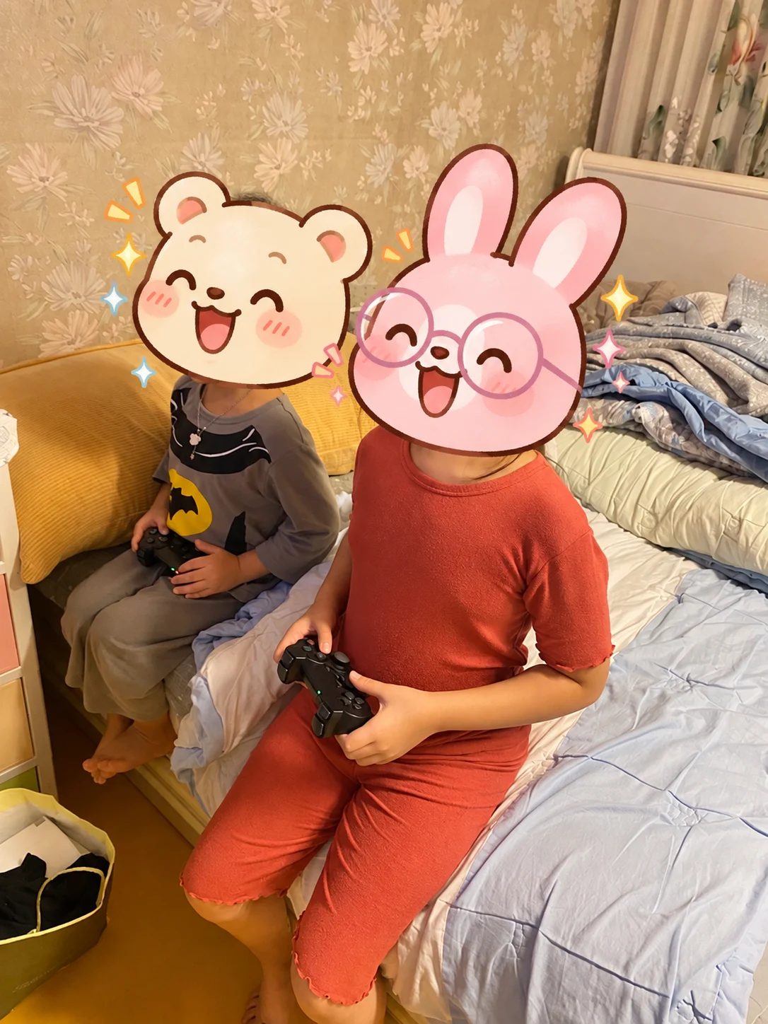 각자 게임패드를 손에 들고 TV 게임을 즐기는 두 아이, 얼굴은 가림 처리